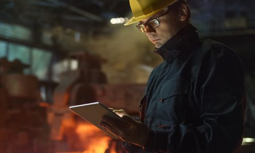 Engineer in Glasses using Tablet PC in Foundry. Industrial Environment.